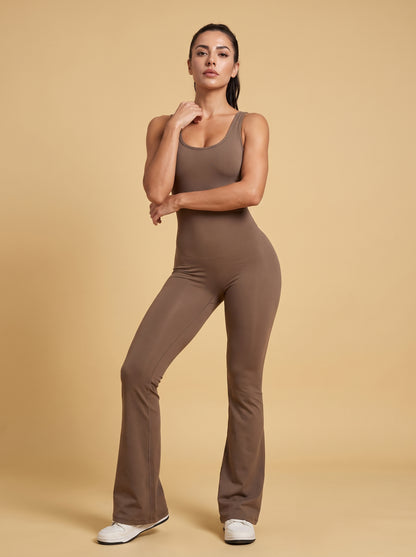 Modelka w szarobrązowym kombinezonie Flame pozuje przodem w studio
